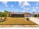 Charming single-story home with manicured landscaping, mature trees, and a long private driveway at 828 Fox Hills Dr, Sun City Center, FL 33573