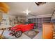 Spacious garage with a car, storage shelves, workbench, and a roll-up door at 828 Fox Hills Dr, Sun City Center, FL 33573