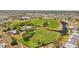 Aerial view of a golf course near a residential area, showcasing green lawns, ponds, and a clubhouse at 828 Fox Hills Dr, Sun City Center, FL 33573