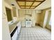 Kitchen with white appliances, cabinets, counters, and tiled floors, with view to a window at 8635 Braxton Dr, Hudson, FL 34667