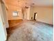 Spacious living room with large window, chandelier and ceiling fan, needing new flooring at 8635 Braxton Dr, Hudson, FL 34667