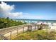 Scenic beach view with a wooden walkway leading to the sandy shore and ocean at 9 Forbes Pl # 310, Dunedin, FL 34698