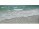 Calm beach waves gently washing ashore on a serene, sunny day near the ocean at 9 Forbes Pl # 310, Dunedin, FL 34698