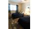 Bedroom featuring two navy beds with decorative pillows and a nightstand with a lamp at 9 Forbes Pl # 310, Dunedin, FL 34698