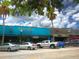 A storefront with vintage signage stands next to parked cars, and is under a cloudy sky at 9 Forbes Pl # 310, Dunedin, FL 34698