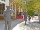 Street scene featuring the statues of a vintage Gathering on a paved sidewalk next to brick building at 9 Forbes Pl # 310, Dunedin, FL 34698