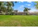 Spacious backyard with expansive lawn, screened-in lanai, and mature trees for privacy at 9712 Tree Tops Lake Rd, Tampa, FL 33626