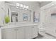 Bright bathroom boasts a double vanity, framed art, and a shower-tub combo with white marble at 9712 Tree Tops Lake Rd, Tampa, FL 33626