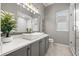 Elegant bathroom with a modern vanity, decorative lighting, and a glass-enclosed shower at 9712 Tree Tops Lake Rd, Tampa, FL 33626