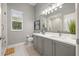 Contemporary bathroom featuring a double vanity, a large mirror, and a glass-enclosed shower at 9712 Tree Tops Lake Rd, Tampa, FL 33626