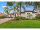 Beautiful home showcasing well-manicured landscaping, a paver driveway, and elegant architectural details at 9712 Tree Tops Lake Rd, Tampa, FL 33626