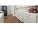 Kitchen area with white cabinets, quartz countertops, stainless steel appliances, and a stylish backsplash at 9712 Tree Tops Lake Rd, Tampa, FL 33626