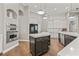 Spacious kitchen with stainless steel appliances, dark cabinetry, a kitchen island, and hardwood floors at 9712 Tree Tops Lake Rd, Tampa, FL 33626