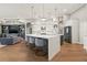 Open-concept kitchen with a large island, pendant lights, a built-in entertainment center, and hardwood floors at 9712 Tree Tops Lake Rd, Tampa, FL 33626