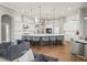 Bright kitchen featuring a large island with pendant lighting, white cabinetry, and hardwood floors at 9712 Tree Tops Lake Rd, Tampa, FL 33626