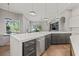 Kitchen island featuring stainless steel dishwasher, quartz countertops, modern appliances, and hardwood floors at 9712 Tree Tops Lake Rd, Tampa, FL 33626