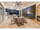 Outdoor kitchen and dining area with lake view, fireplace, and ceiling fan for ultimate comfort at 9712 Tree Tops Lake Rd, Tampa, FL 33626