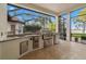 Built-in outdoor kitchen with stainless steel appliances and beautiful views of the lake at 9712 Tree Tops Lake Rd, Tampa, FL 33626