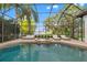 Relaxing screened-in pool area with a spa and outdoor lounge seating overlooking the lake at 9712 Tree Tops Lake Rd, Tampa, FL 33626
