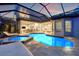 Stunning pool area at dusk, with an in-ground pool, spa, and plenty of lounge space at 9712 Tree Tops Lake Rd, Tampa, FL 33626