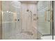 Modern shower with marble-look tile, a built-in bench, and a rainfall shower head at 9712 Tree Tops Lake Rd, Tampa, FL 33626