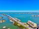 Beautiful aerial view of a waterfront home, bridge, and bay with blue skies in desirable beach community at 100 Bluff View Dr # 115C, Belleair Bluffs, FL 33770