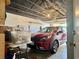 Attached two-car garage features a red Kia Niro, storage, and easy access to the home at 100 Bluff View Dr # 115C, Belleair Bluffs, FL 33770