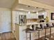 Well-equipped kitchen with white cabinets, stainless steel refrigerator and breakfast bar at 100 Bluff View Dr # 115C, Belleair Bluffs, FL 33770