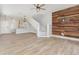 Open-concept living room with hardwood floors, a modern accent wall, and staircase at 10966 Winter Crest Dr, Riverview, FL 33569