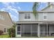 Rear view of property with screened patio, blue sky, and green lawn at 10966 Winter Crest Dr, Riverview, FL 33569
