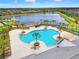 Aerial view of a large community pool, lake, and lounging area with palm trees at 11434 Leland Groves Dr, Riverview, FL 33579