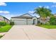 Charming single-Gathering home with a three-car garage and manicured front lawn at 11434 Leland Groves Dr, Riverview, FL 33579