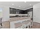 Stylish kitchen showcasing dark cabinets, granite counters, a large island, and stainless steel appliances at 11434 Leland Groves Dr, Riverview, FL 33579