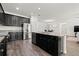 Open-concept kitchen with a large island, dark cabinets, stainless steel appliances, and granite countertops at 11434 Leland Groves Dr, Riverview, FL 33579