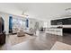 Open concept living area featuring sleek hardwood floors, a breakfast bar, and dark kitchen cabinets at 11434 Leland Groves Dr, Riverview, FL 33579