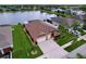 Aerial view of the home, showing the roof, backyard, pool, lawn, landscaping, and proximity to the lake at 11614 Ashton Field Ave, Riverview, FL 33579