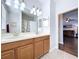 Well-lit bathroom featuring a double sink vanity, large mirror, and stylish tile flooring at 11614 Ashton Field Ave, Riverview, FL 33579
