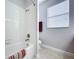 Bright bathroom with a shower over tub, toilet, and tiled floor at 11614 Ashton Field Ave, Riverview, FL 33579