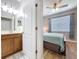 Bedroom showcasing wood floors, natural light through blinds, a ceiling fan and a partial view of the bathroom at 11614 Ashton Field Ave, Riverview, FL 33579