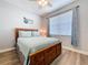Well-lit bedroom features a wood bed frame, ceiling fan, and a large window at 11614 Ashton Field Ave, Riverview, FL 33579