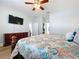 Bedroom with wood floor, ceiling fan, dresser with mounted TV and doorways to additional rooms at 11614 Ashton Field Ave, Riverview, FL 33579