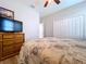 Cozy bedroom featuring a ceiling fan, closet, and a light wood dresser with a flat screen TV at 11614 Ashton Field Ave, Riverview, FL 33579