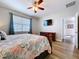 Bedroom with wood floor, ceiling fan, dresser with mounted tv above and an open doorway to an adjacent room at 11614 Ashton Field Ave, Riverview, FL 33579