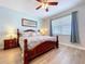 Bright bedroom featuring wood flooring, a four-poster bed with a ceiling fan and a window allowing natural light to filter in at 11614 Ashton Field Ave, Riverview, FL 33579