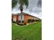 Well-maintained home exterior with a lush lawn, beautiful landscaping, and storm shutters at 11614 Ashton Field Ave, Riverview, FL 33579
