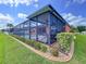 Exterior view of the home with a screened-in patio, and green lawn with beautiful landscaping at 11614 Ashton Field Ave, Riverview, FL 33579