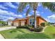 Charming single-story home with a three-car garage, well-maintained landscaping, and an orange painted stucco facade at 11614 Ashton Field Ave, Riverview, FL 33579