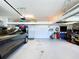Organized garage with tools, equipment, storage racks, and a car parked inside at 11614 Ashton Field Ave, Riverview, FL 33579