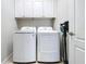 Clean and organized laundry room featuring a washer, dryer, white cabinets, and a vacuum cleaner at 11614 Ashton Field Ave, Riverview, FL 33579