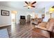 Open-concept living room with wood floors, a large TV, and a view of the kitchen and other living spaces at 11614 Ashton Field Ave, Riverview, FL 33579